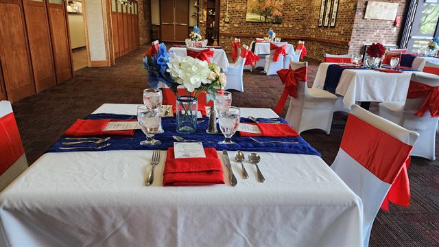 Banquet tables in red, white, and blue with red chair sashes