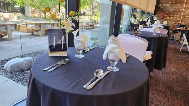 Numbered table set by the window with a yellow floral centerpiece